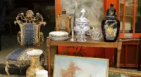 a table topped with a painting next to a chair